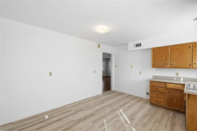 a room with a bed and a view of kitchen