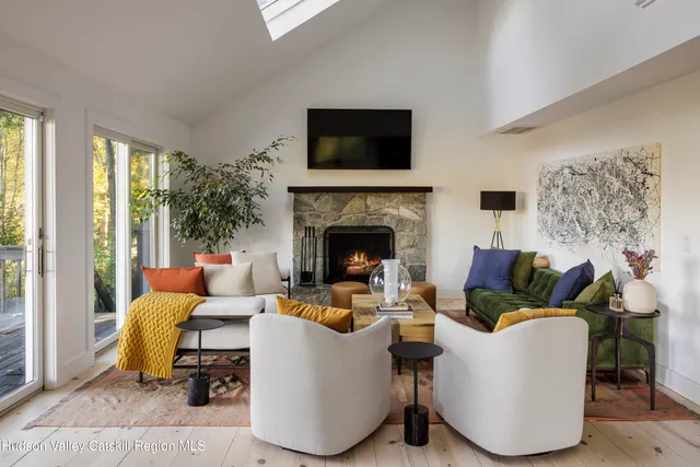 a living room with furniture a flat screen tv and a fireplace