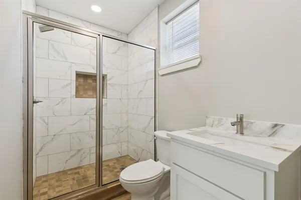 a bathroom with a sink a toilet and shower