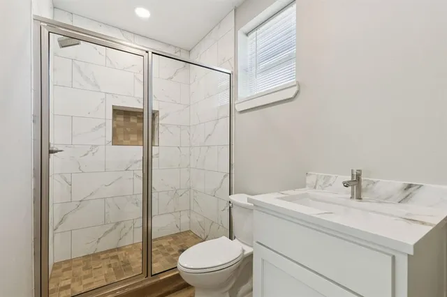 a bathroom with a sink a toilet and shower