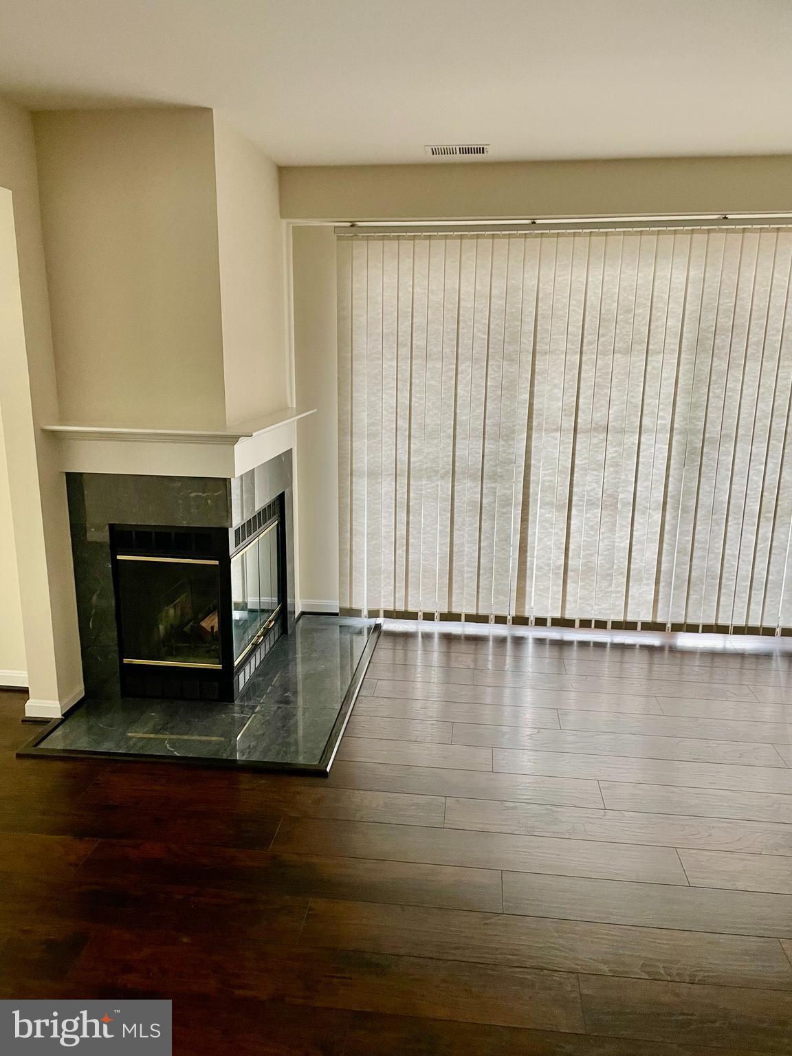 102 Kendrick Place, Unit 10222 Gaithersburg, MD 20878 - Photo 3 of 17 a view of an empty room with wooden floor and a fireplace