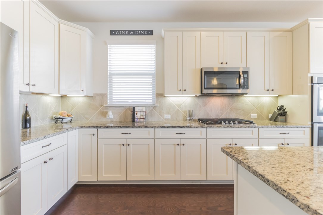 a kitchen with granite countertop white cabinets and sink