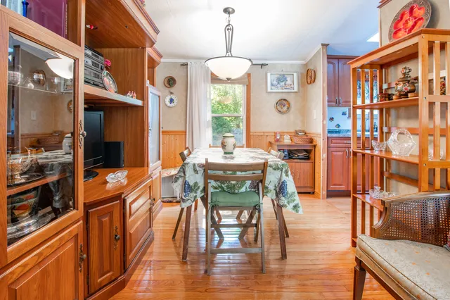 a dining room with furniture a chandelier and wooden floor