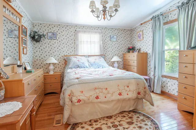 a large bed sitting in a bedroom next to a window with dresser