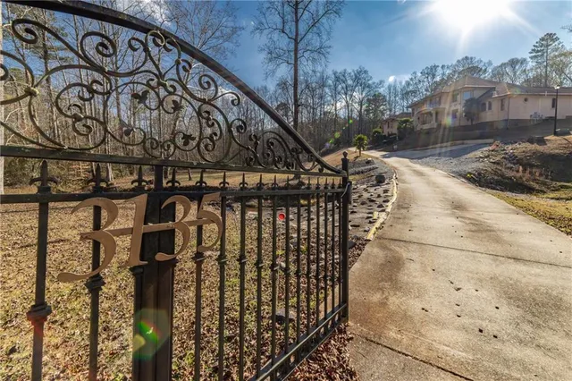a view of a white house with large windows next to a yard