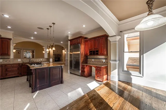 a view of a big room with windows and chandelier fan