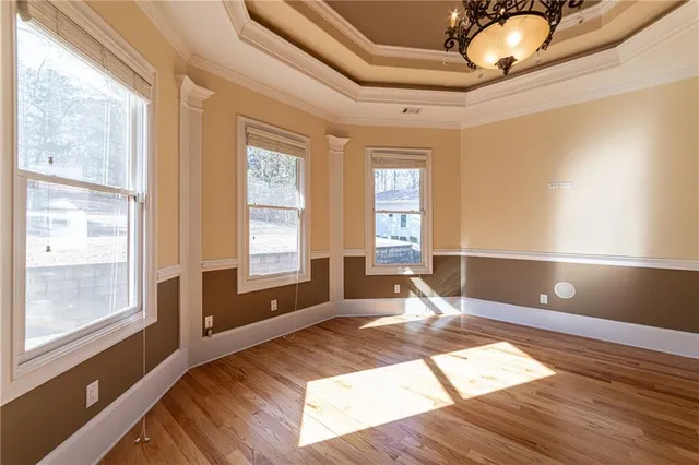 a view of a livingroom with a chandelier wooden floor and a ceiling fan