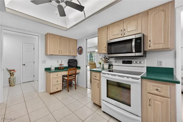 a kitchen with granite countertop a stove top oven microwave and cabinets