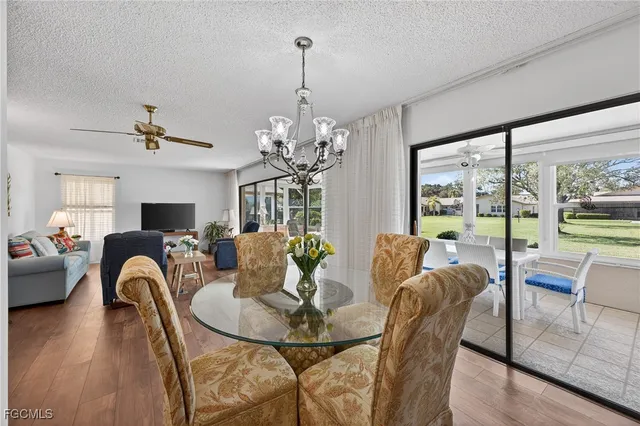 a view of a dining room with furniture a chandelier and wooden floor