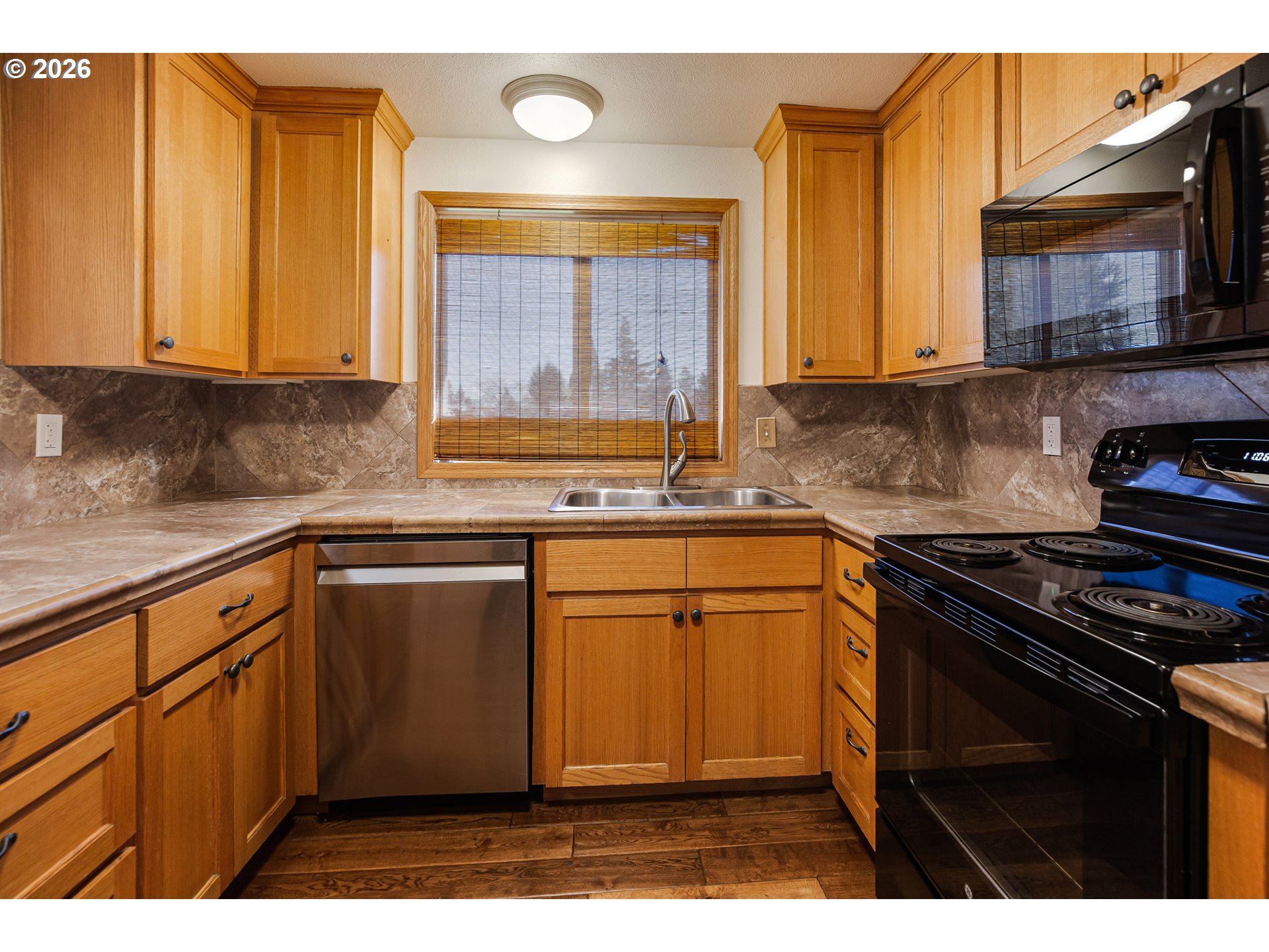 913 South Fir Court Canby, OR 97013 - Photo 5 of 37 a kitchen with stainless steel appliances granite countertop a stove a sink and a microwave