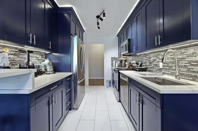 a kitchen with stainless steel appliances granite countertop a sink stove and cabinets