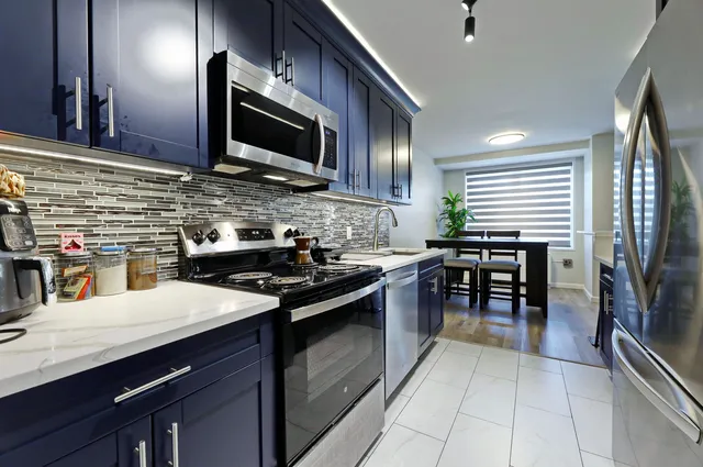 a kitchen with stainless steel appliances granite countertop a stove a sink and a microwave