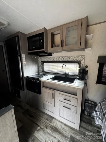a kitchen with stainless steel appliances a table chairs and a refrigerator