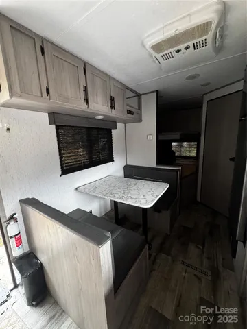 a living room with stainless steel appliances granite countertop hardwood floor sink stove and window