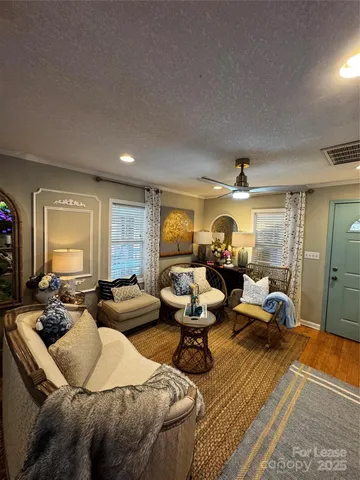 a living room with furniture a large window and gym equipment