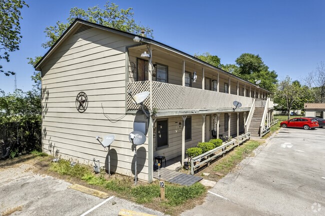 201 Sands Street, Unit 19 Angleton, TX 77515 - Photo 2 of 6 a view of a white house with a small yard and large tree and plants