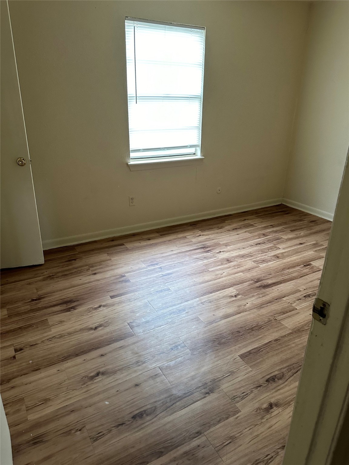 201 Sands Street, Unit 19 Angleton, TX 77515 - Photo 4 of 6 an empty room with wooden floor and windows