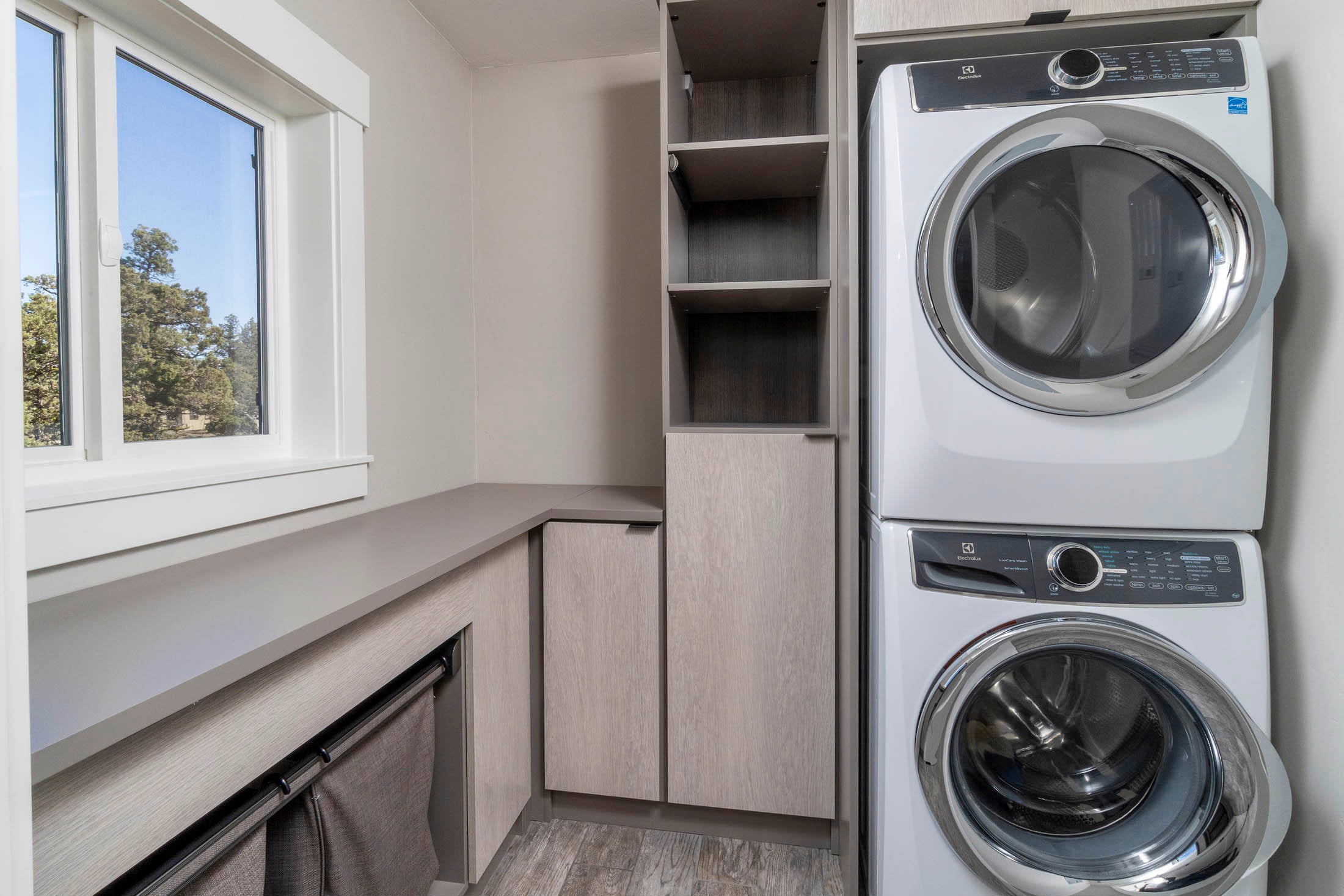 64486 McGrath Road Bend, OR 97701 - Photo 17 of 38 Laundry room through primary closet with full size stacking Elextrolux washer and dryer. Closet and laundry with California Closets cabinetry
