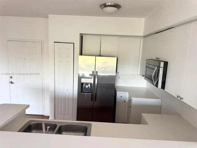 a kitchen with stainless steel appliances a refrigerator and a sink
