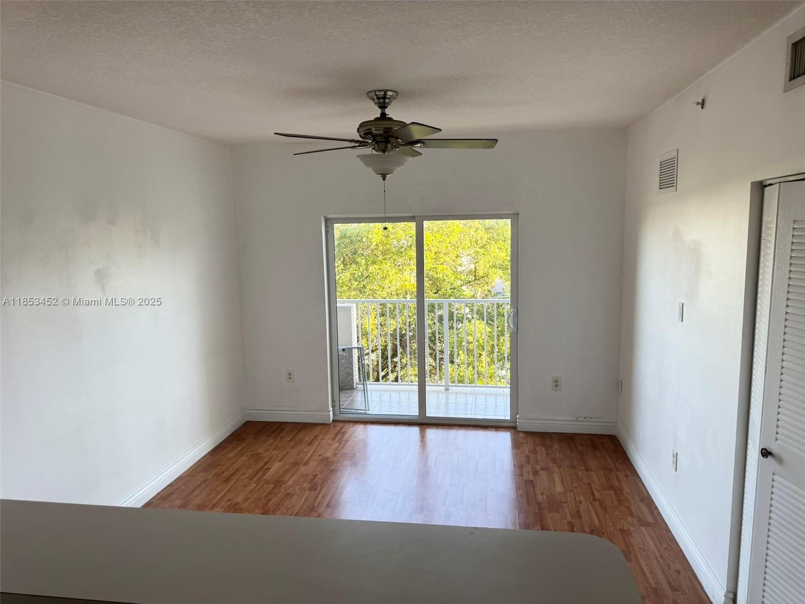 11060 Southwest 196th Street, Unit 512 Cutler Bay, FL 33157 - Photo 6 of 19 an empty room with wooden floor and windows