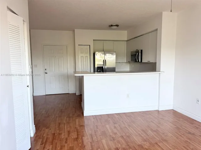 a view of a kitchen cabinets a sink and wooden floor