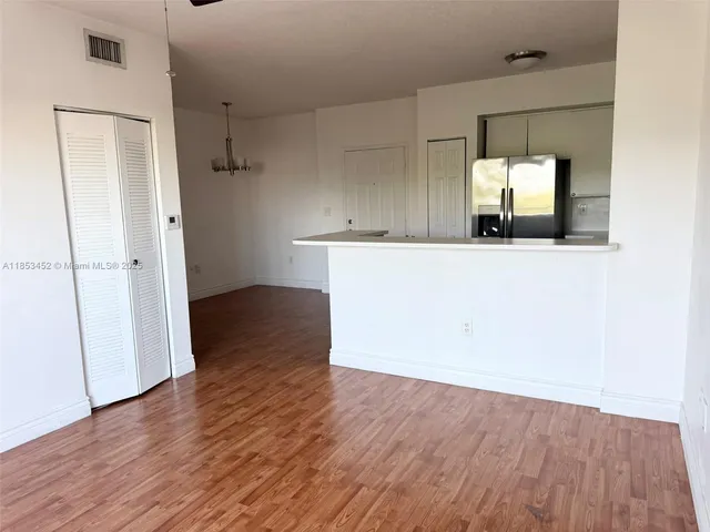 an empty room with wooden floor and mirror