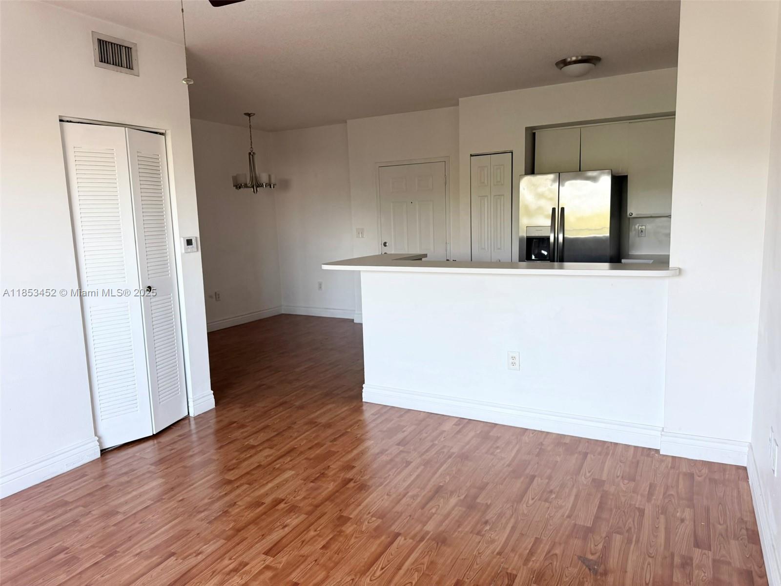 11060 Southwest 196th Street, Unit 512 Cutler Bay, FL 33157 - Photo 8 of 19 an empty room with wooden floor and mirror