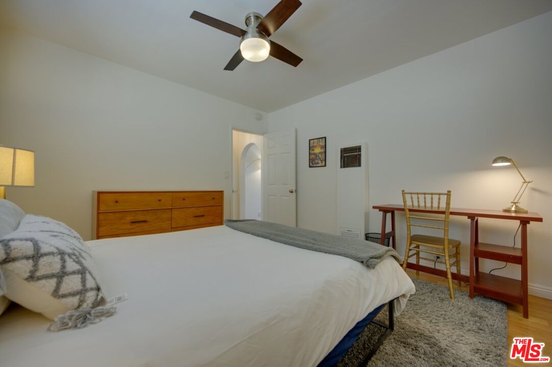 1918 11th Street, Unit F Santa Monica, CA 90404 - Photo 12 of 14 a bedroom with a bed a lamp and a dresser