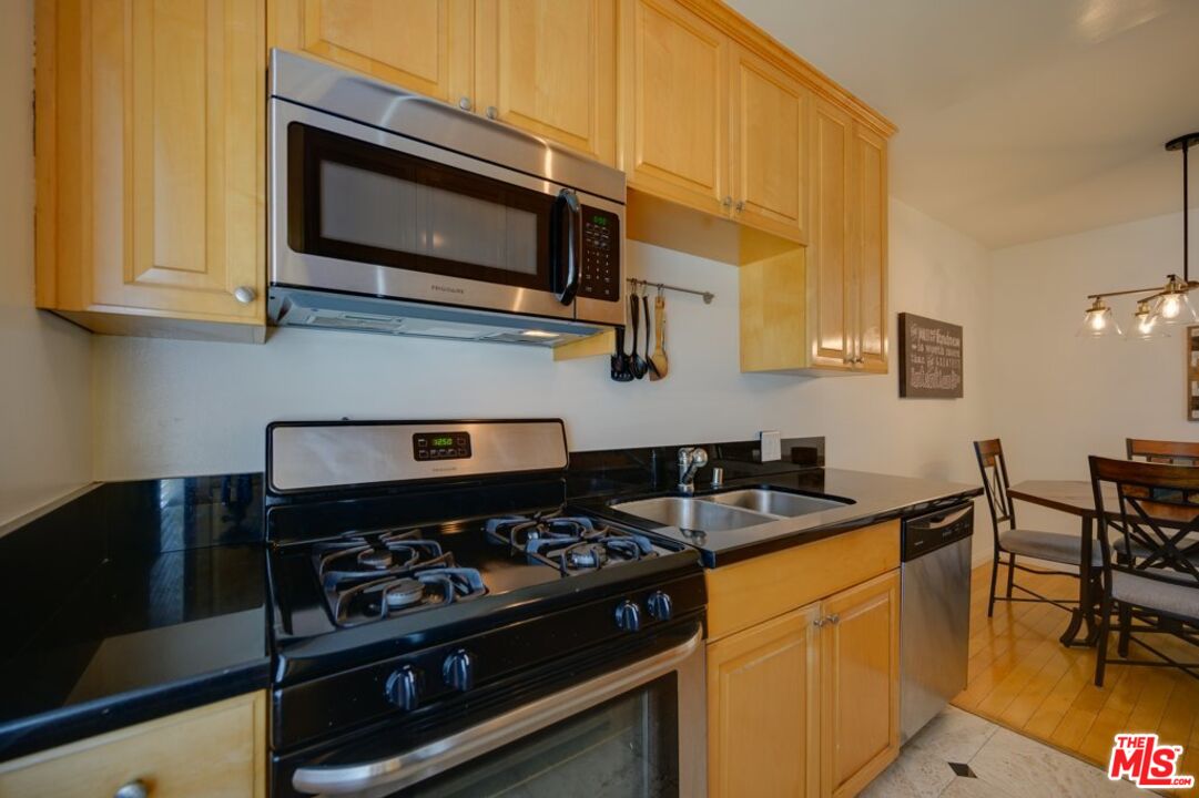 1918 11th Street, Unit F Santa Monica, CA 90404 - Photo 4 of 14 a kitchen with stainless steel appliances a stove a microwave a sink and cabinets
