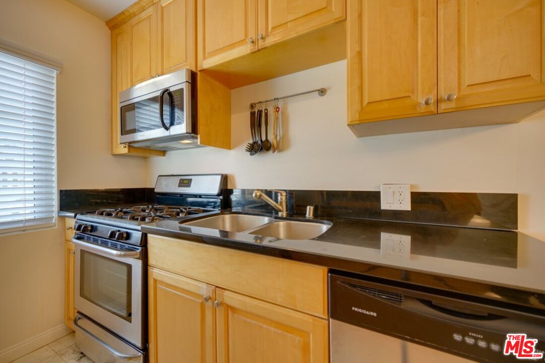 1918 11th Street, Unit F Santa Monica, CA 90404 - Photo 5 of 14 a kitchen with stainless steel appliances granite countertop a sink and a stove