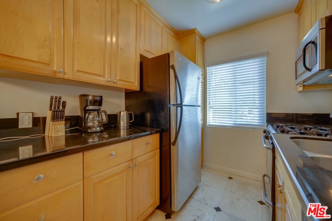 1918 11th Street, Unit F Santa Monica, CA 90404 - Photo 6 of 14 a kitchen with stainless steel appliances granite countertop a refrigerator and a sink