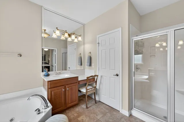 a en suite bathroom with a sink a large mirror and a shower
