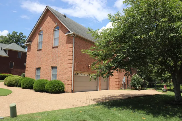 a view of a big house with a big yard and potted plants