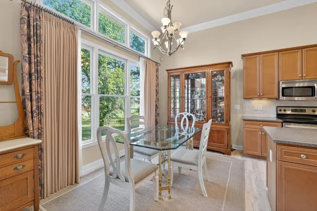 a dining room with furniture a chandelier and wooden floor