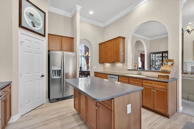 a kitchen with stainless steel appliances granite countertop a refrigerator a sink and a stove