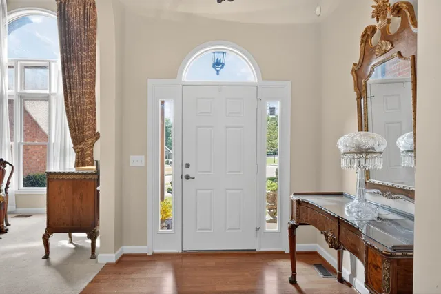 a view of a hallway with entryway wooden floor and front door