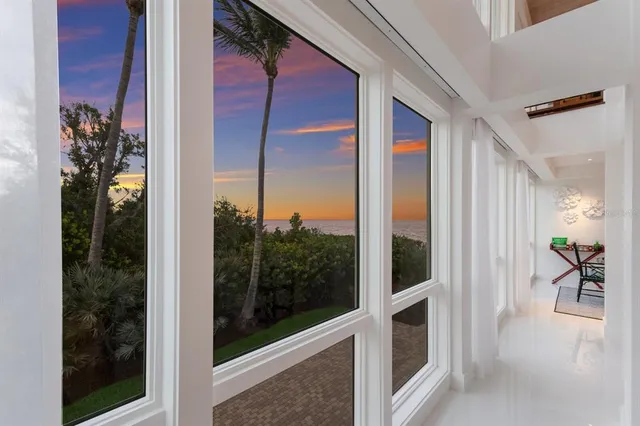 a dining room with furniture a rug and a floor to ceiling window
