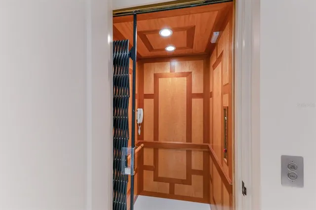 a room with lots of tables a large window and chairs