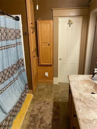 a bathroom with a granite countertop sink a mirror and shower