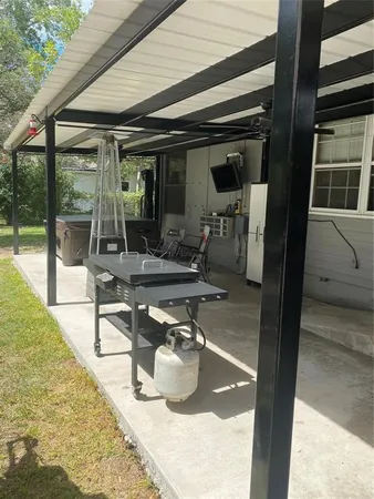 a view of a chairs and table in patio with a backyard