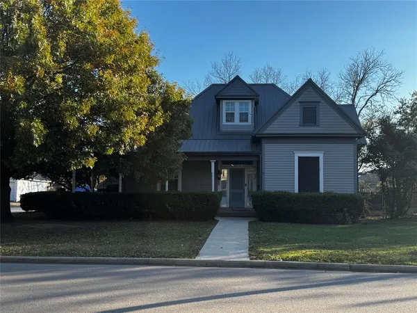 a front view of a house with garage and trees