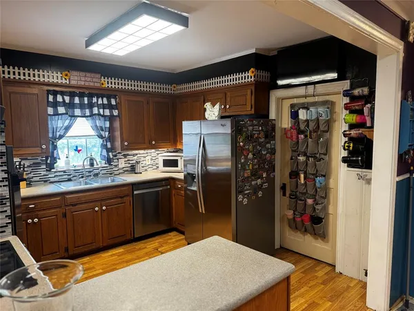 a kitchen with stainless steel appliances granite countertop a refrigerator and a sink