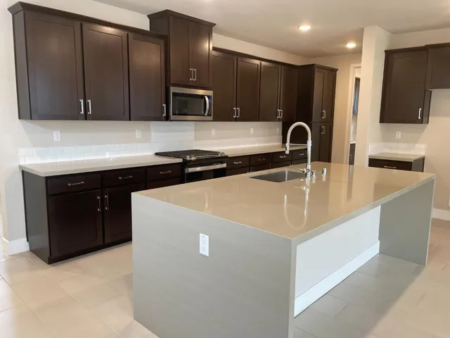a kitchen with stainless steel appliances granite countertop a sink and a refrigerator