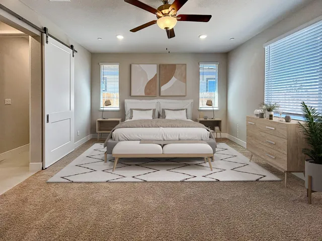 a spacious bedroom with a large bed and a chandelier