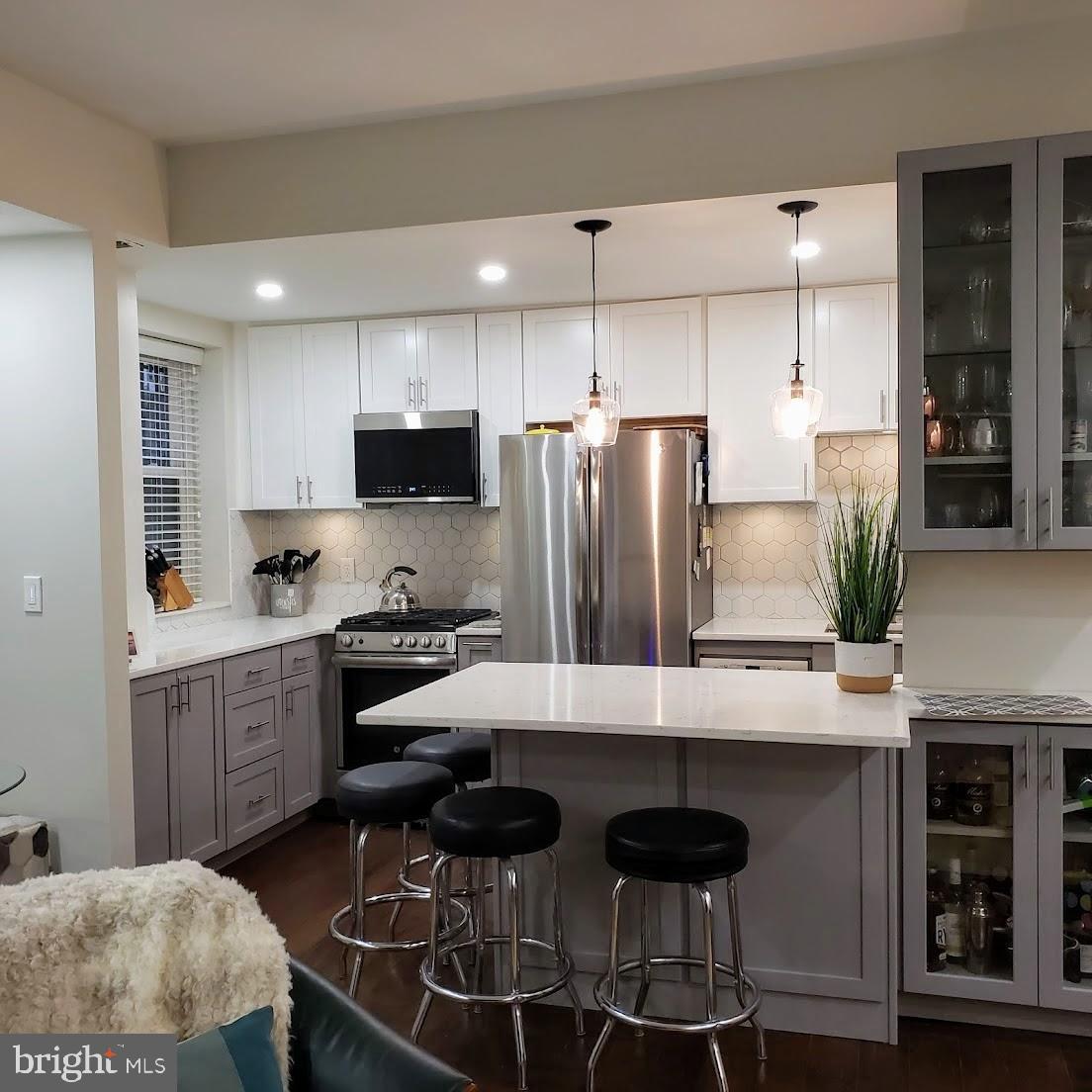 2127 California Street Northwest, Unit 102 Washington, DC 20008 - Photo 4 of 10 a kitchen with stainless steel appliances granite countertop a stove refrigerator sink and cabinets