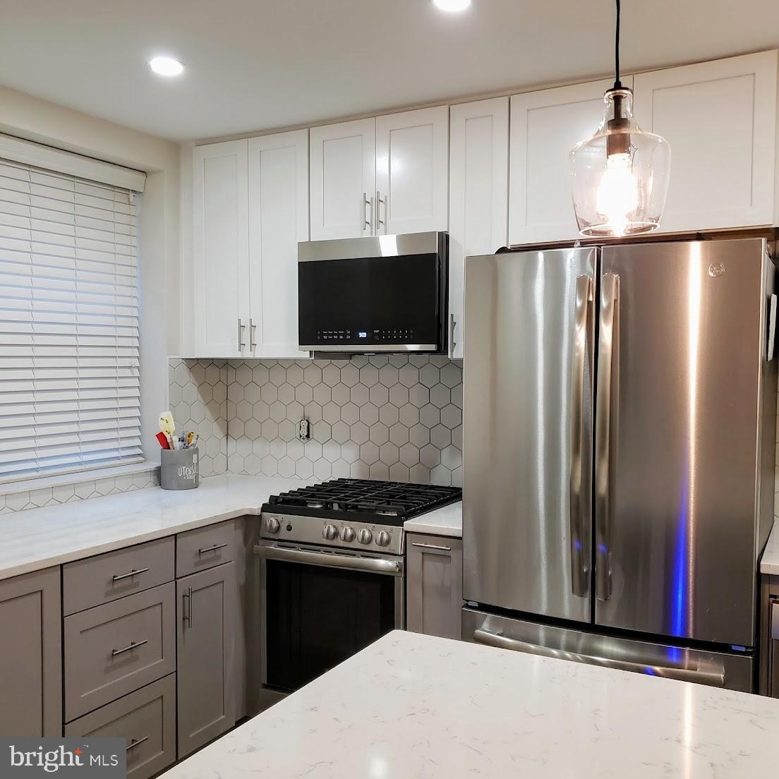 2127 California Street Northwest, Unit 102 Washington, DC 20008 - Photo 5 of 10 a kitchen with stainless steel appliances granite countertop a refrigerator a stove and a sink