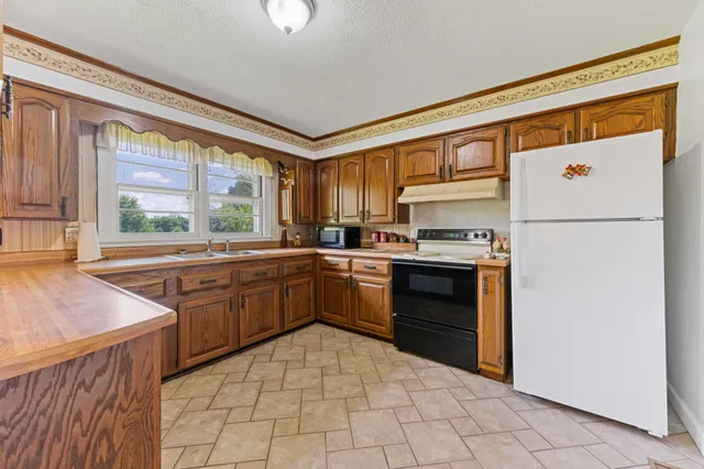 a kitchen with stainless steel appliances a refrigerator sink and microwave