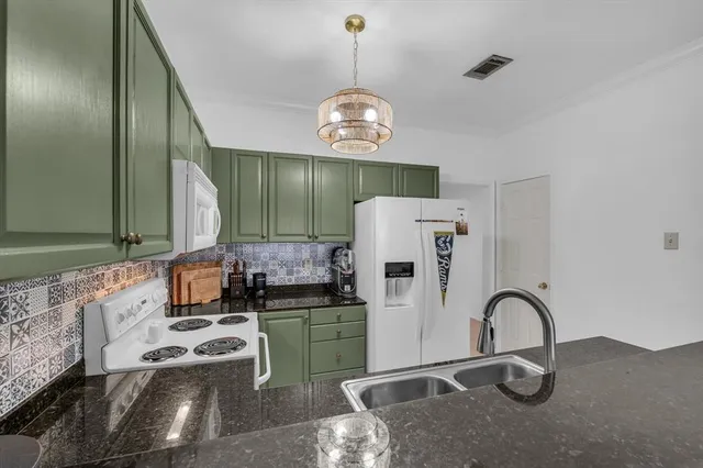 a kitchen with stainless steel appliances granite countertop a sink a stove and a refrigerator