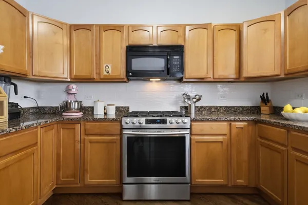 a kitchen with stainless steel appliances granite countertop a sink stove and microwave
