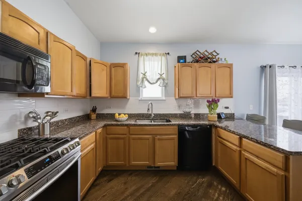 a kitchen with a sink stove top oven and cabinets